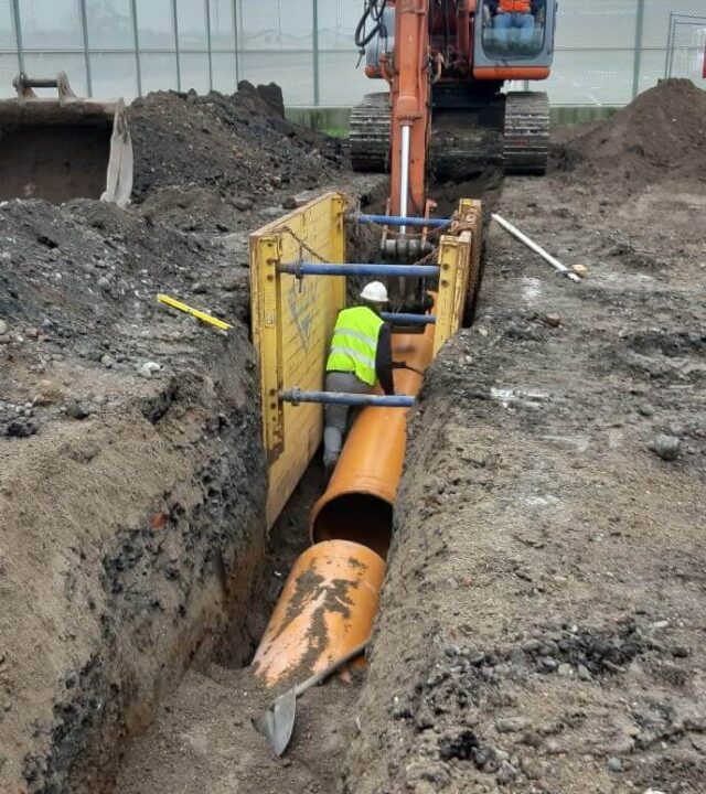 escavatore al lavoro per uno scavo alla rete fognaria di un cantiere