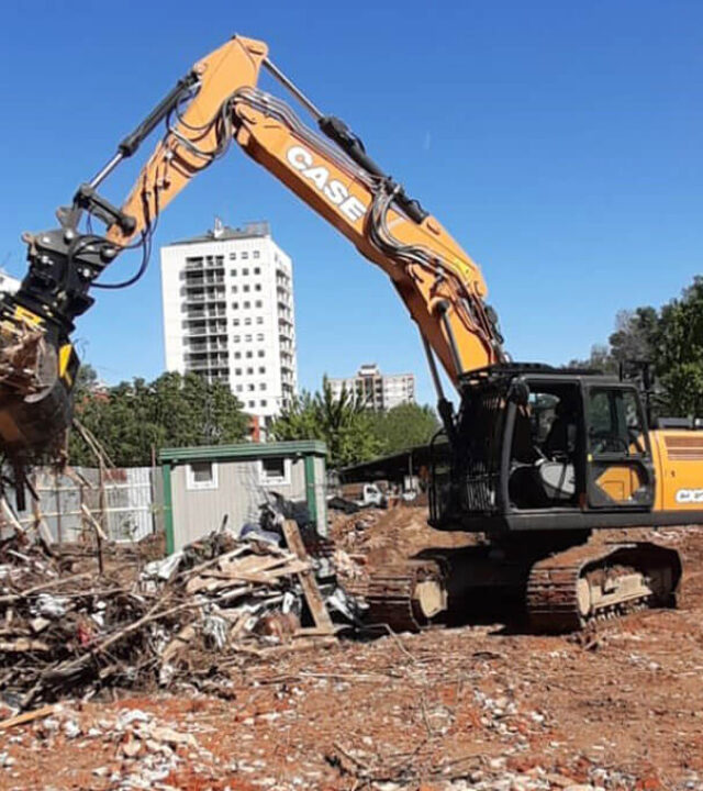 demolizione e strip out in un cantiere industriale eseguito da un escavatore