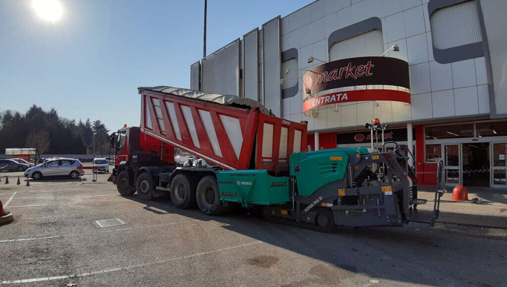 camion di Scavi Pizzetti che esegue un lavoro stradale davanti ad un supermercato