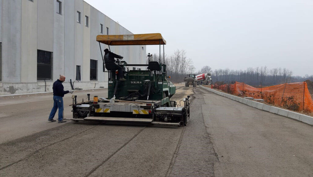 esecuzione di una rullatura e stesura di un manto stradale in area industriale